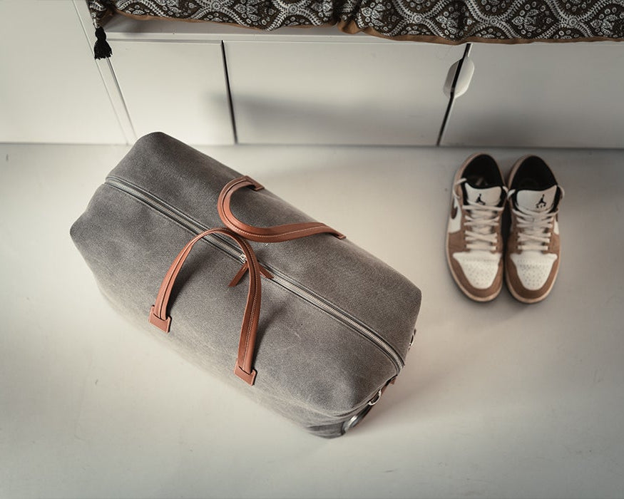 Sac de voyage en toile de coton et cuir lisse.