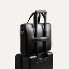 Briefcase en cuir avec passant trolley, idéal pour voyager avec une valise.