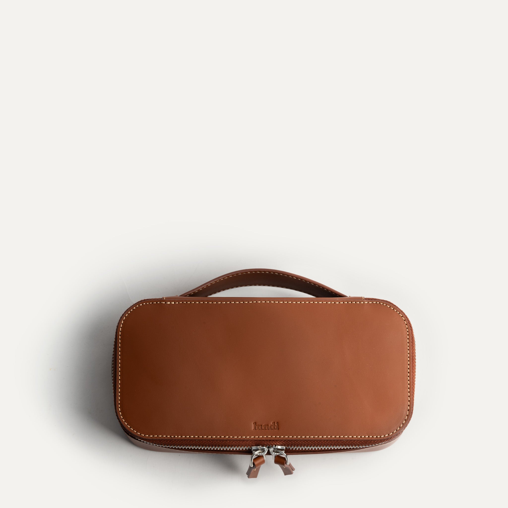 Trousse de toilette homme luxe en cuir cognac.