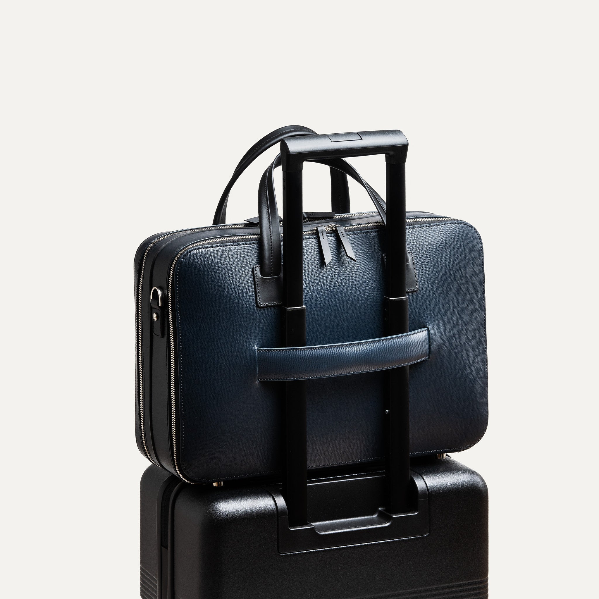 Porte document Cardignac en cuir marine de lundi avec un passant pour valise intégré.