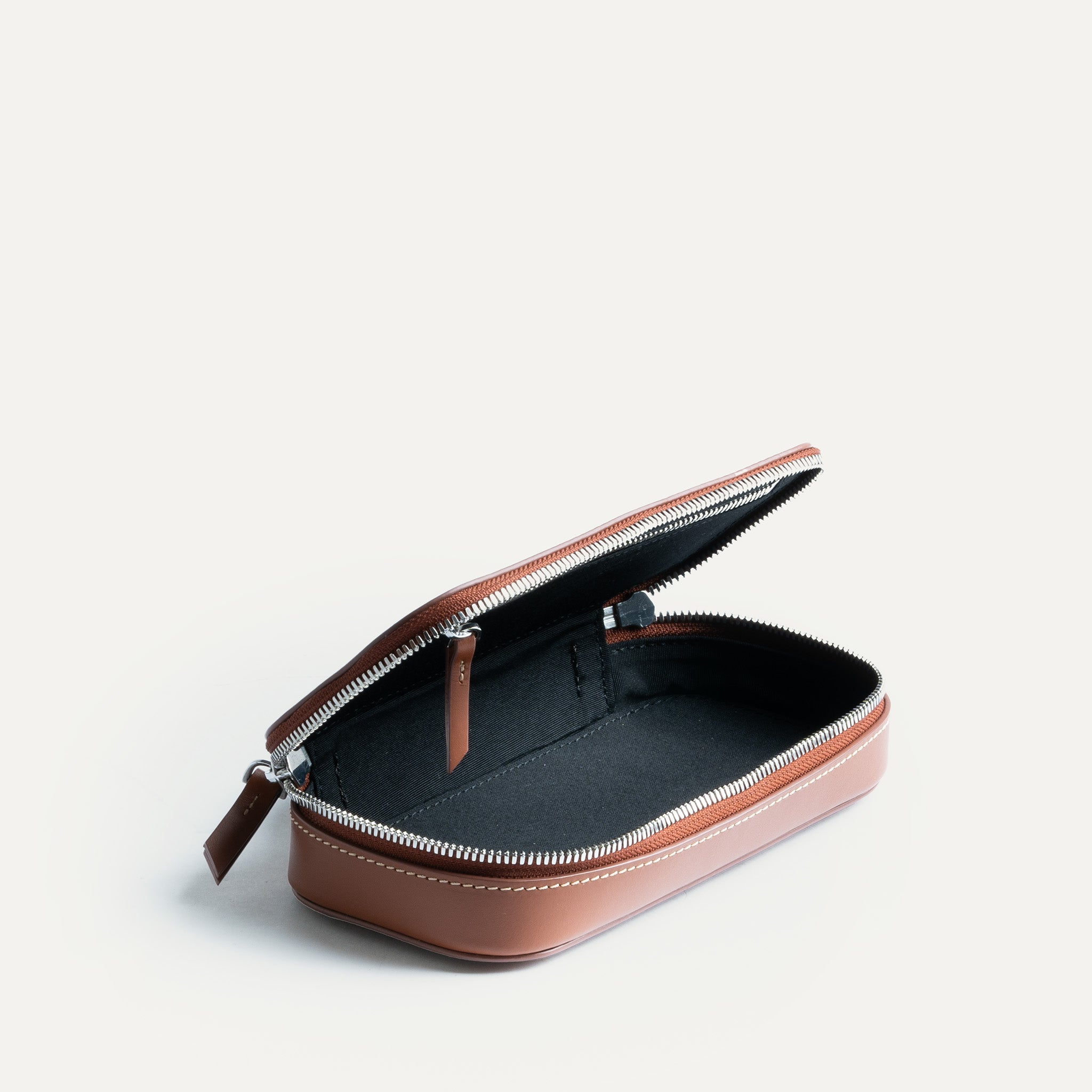 Trousse de toilette pour homme de luxe en cuir de couleur cognac avec une grande poche de rangement.