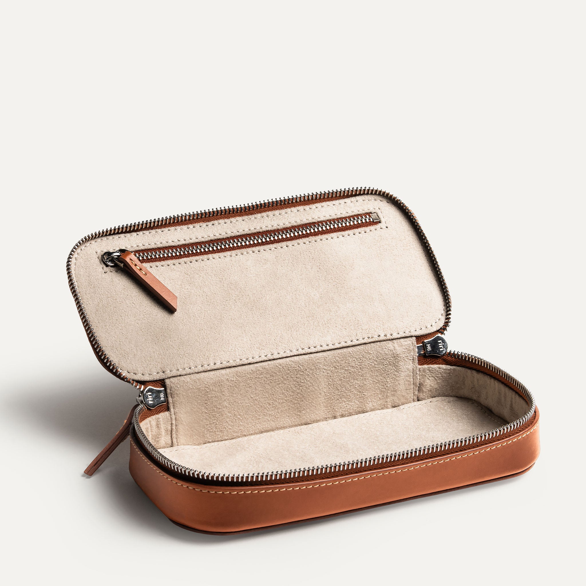 Trousse de toilette pour homme de luxe en cuir de couleur cognac avec une grande poche de rangement.