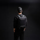 Homme portant un sac à dos en cuir 40x20x25 pour ordinateur, parfait pour se déplacer et les voyages cabine.