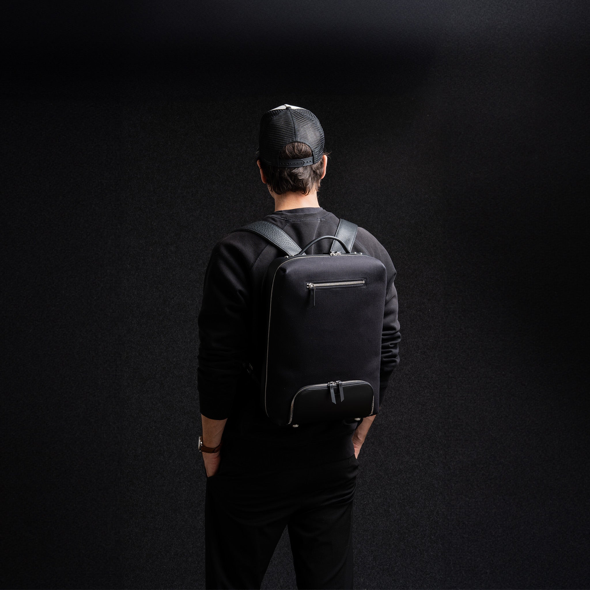Homme portant un sac à dos en cuir 40x20x25 pour ordinateur, parfait pour se déplacer et les voyages cabine.