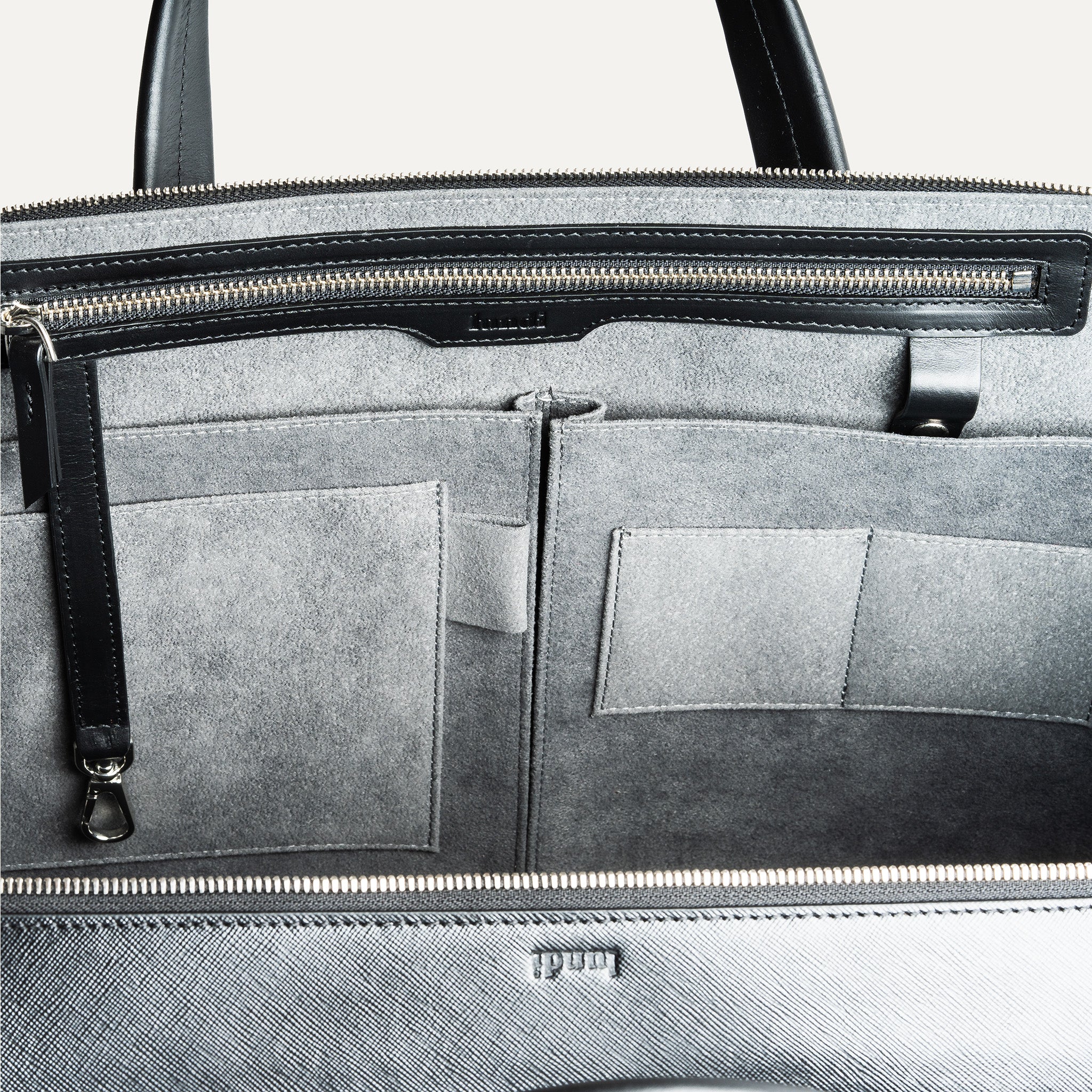 Briefcase en cuir avec des poches intérieurs pour les accessoires du quotidien.