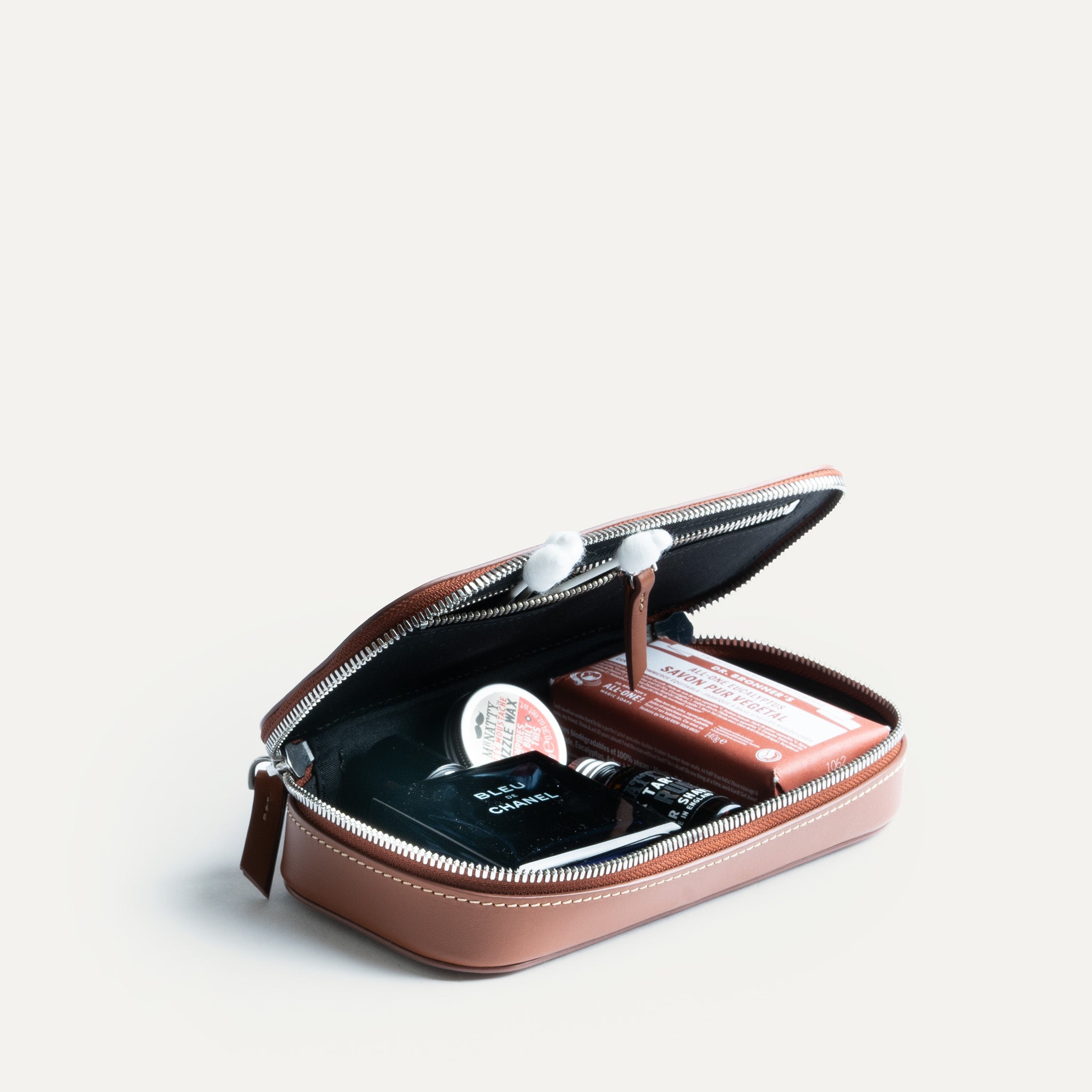 Trousse de toilette homme en cuir ouverte avec une capacité de rangement fonctionnelle.