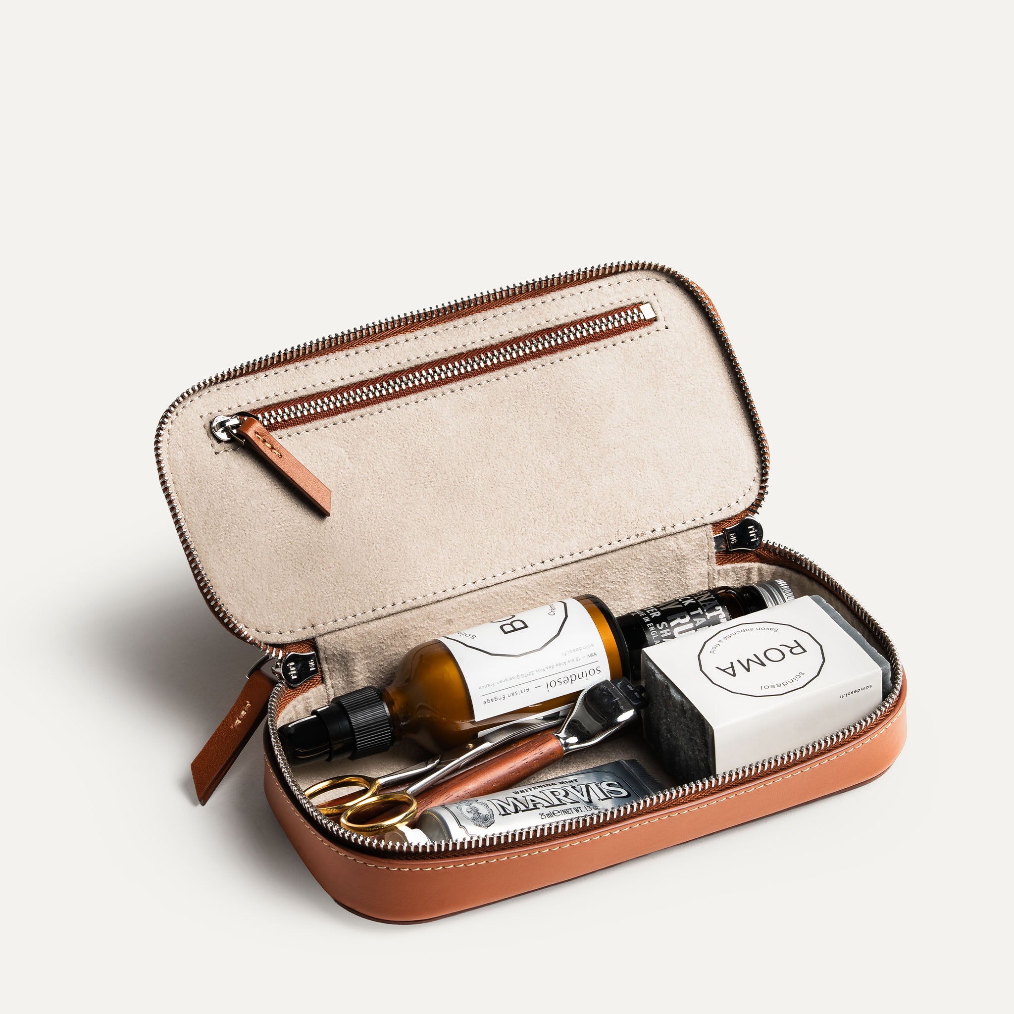 Trousse de toilette homme en cuir ouverte avec une capacité de rangement fonctionnelle.