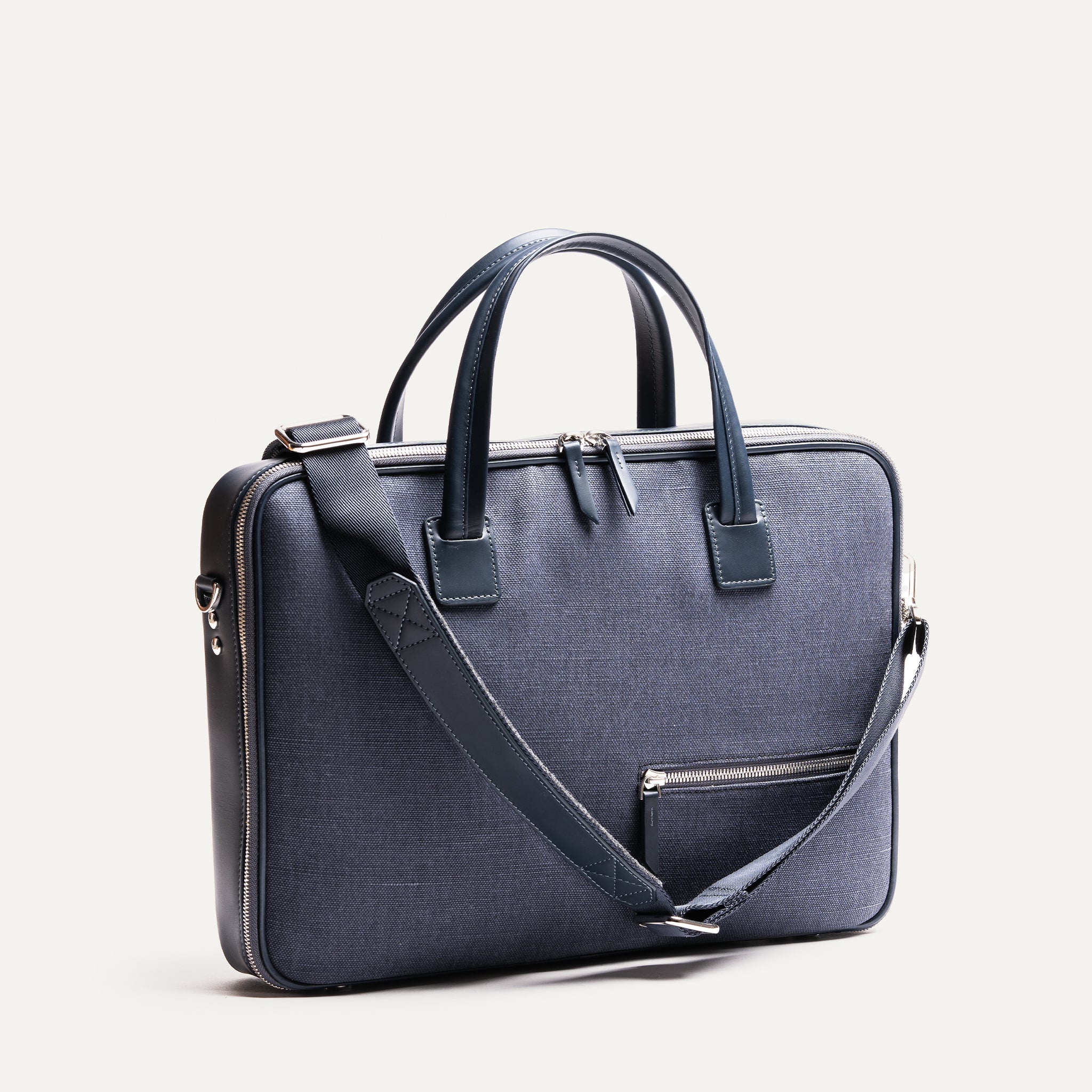 Sac à bandoulière homme en cuir et toile marine, léger et pratique pour transporter tout le nécessaire en déplacement.