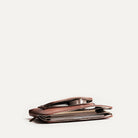 Pochette ordinateur femme en cuir, compartiment principal et poches ouvertes pour chargeur et câbles.