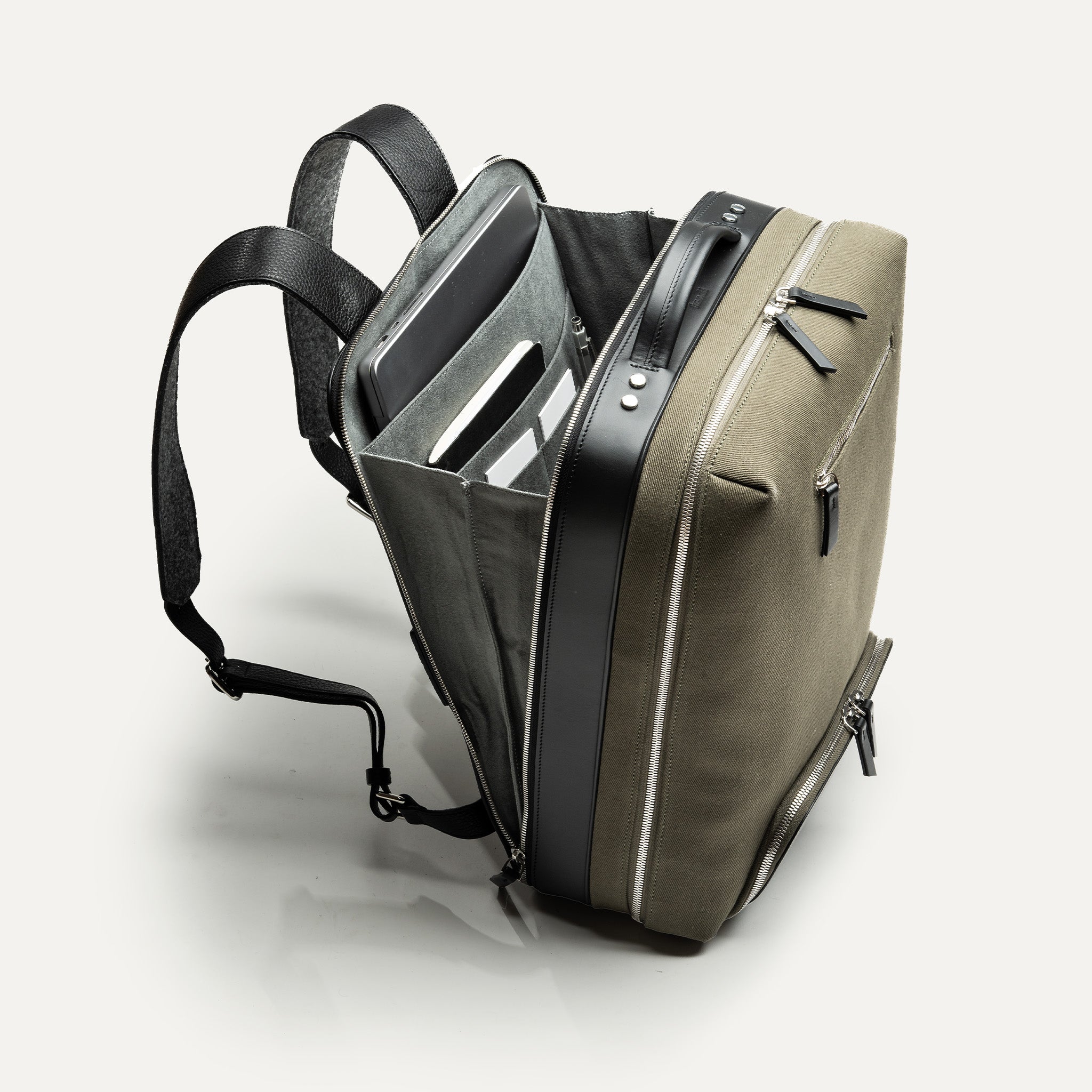 Sac à dos homme cuir noir et toile kaki avec rangements organisés, parfait pour emporter vêtements et dossiers