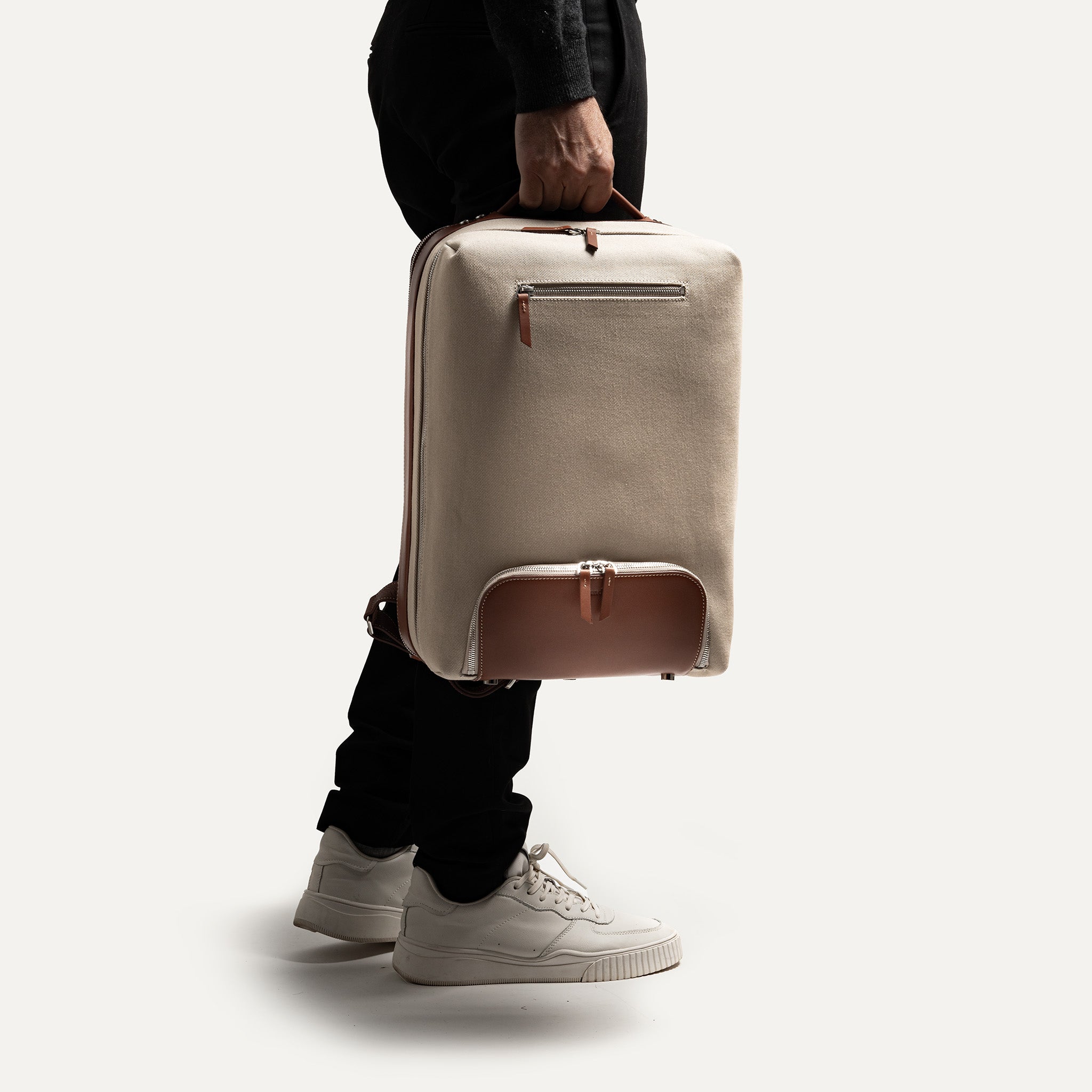 Ce sac à dos en cuir et toile sable est durable et comporte une poignée de transport tout en cuir