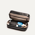 Grande trousse de toilette pour homme ouverte en partie, illustrant l'intérieur spacieux et ses rangements dédiés.