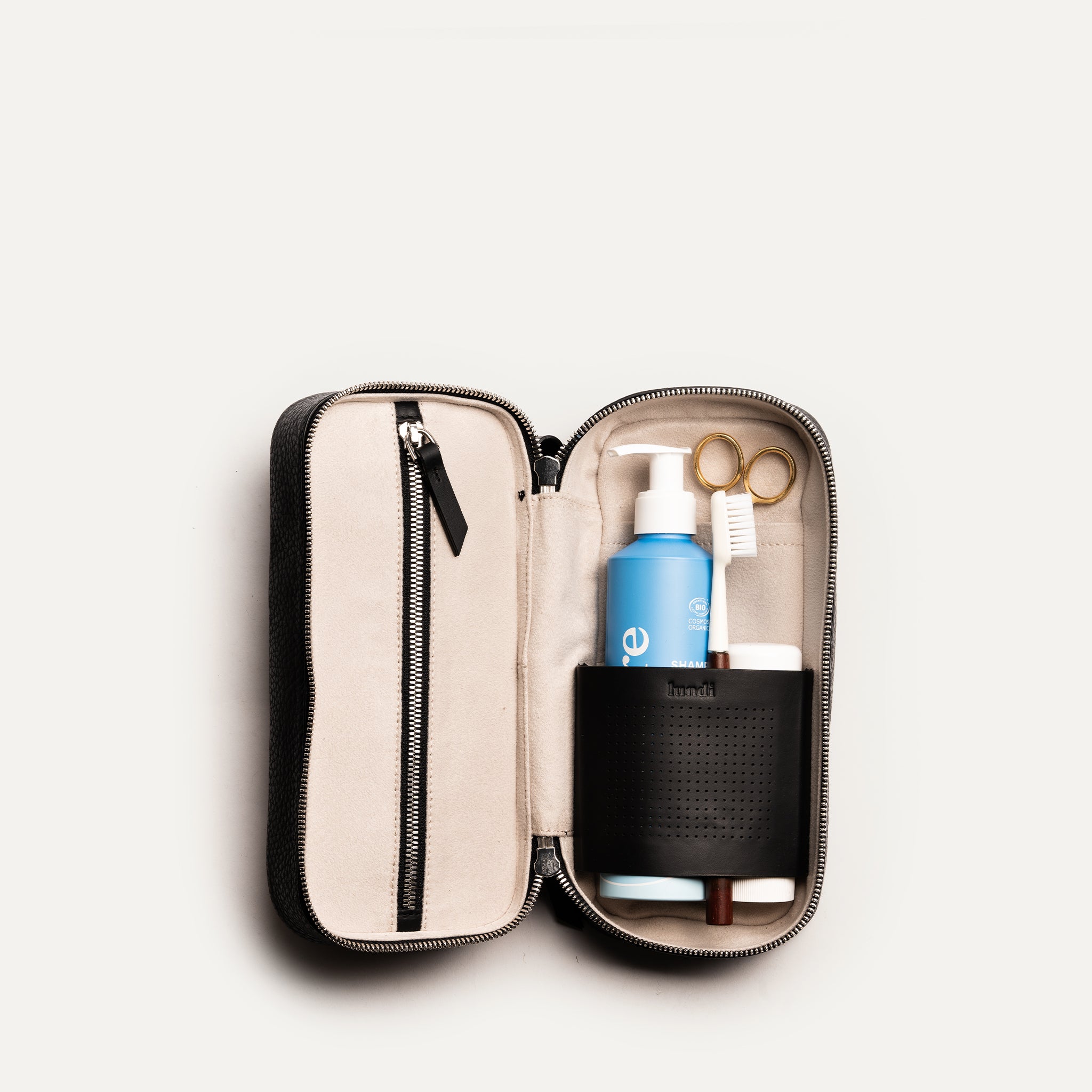 Trousse de toilette homme ouverte montrant les compartiments internes et poches zippées pour une organisation optimale.