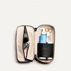 Trousse de toilette de luxe femme vue de haut, avec intérieur en tissu clair et fermeture éclair, parfaite pour les déplacements.