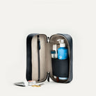 Trousse de toilette de luxe femme ouverte verticalement, avec produits de beauté bien rangés dans les compartiments.