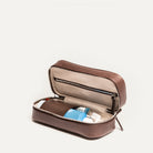 Trousse de toilette de voyage ouverte vue en angle, avec flacons et produits de toilette organisés à l’intérieur.