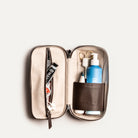 Trousse de toilette cuir pour homme ouverte avec produits de soin et accessoires parfaitement organisés.