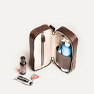 Trousse de toilette homme luxe ouverte verticalement, exposant les produits de soin et accessoires de beauté.