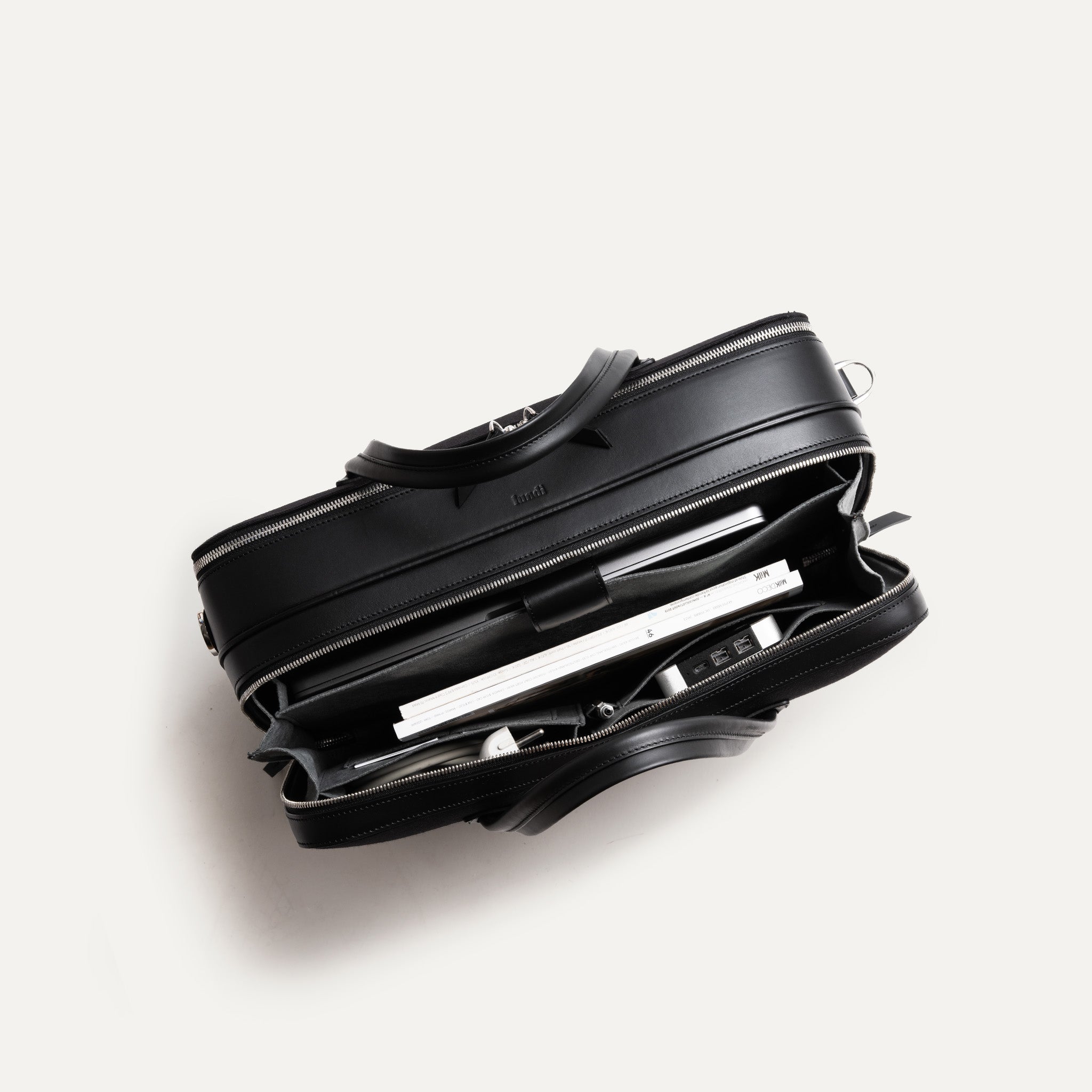 Sac à main homme en toile et cuir noir montrant son organisation intérieure pratique.