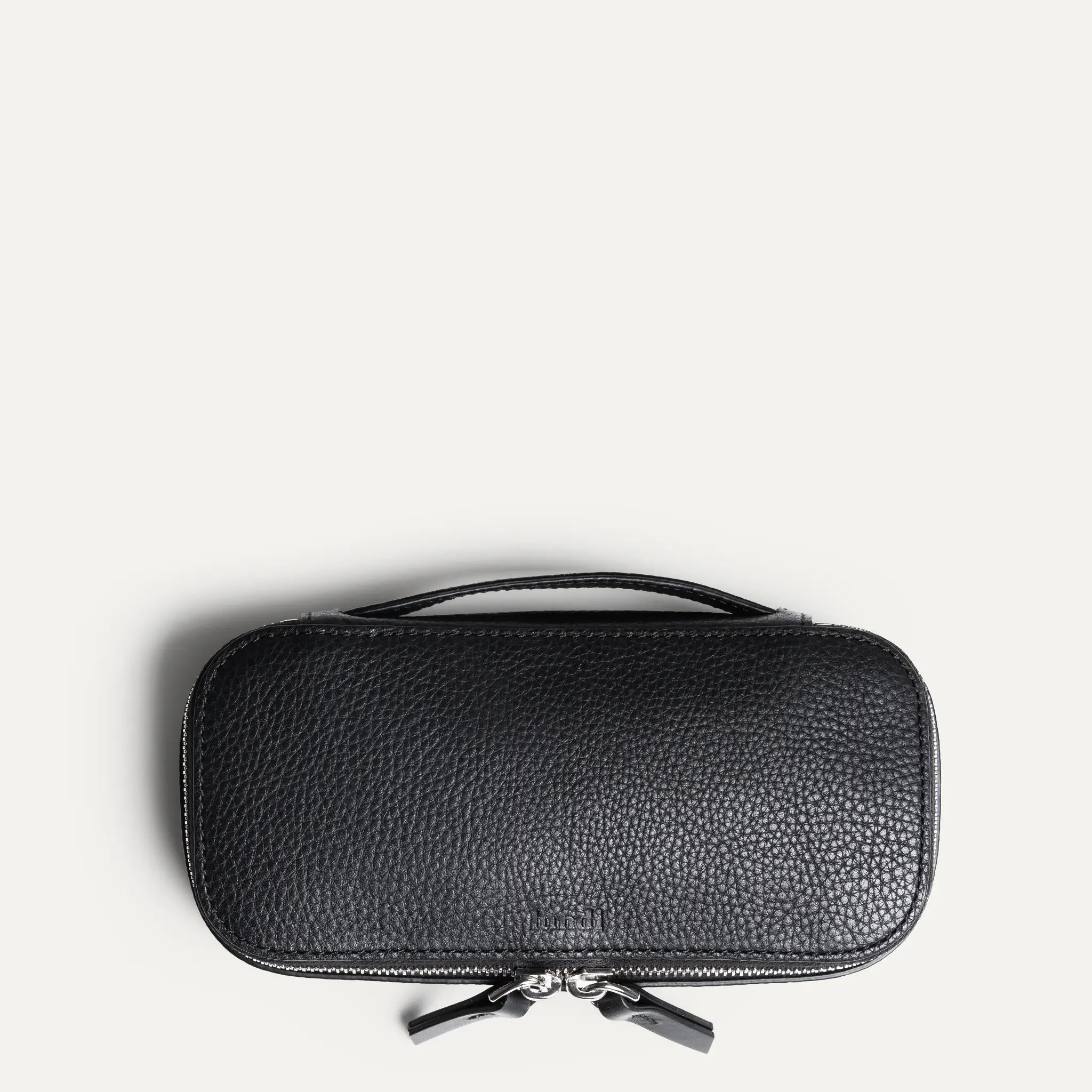 Trousse de toilette très compacte en cuir grainé vue de dessus.