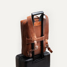 Sac à dos de voyage homme fixé sur valise, parfait pour les déplacements professionnels.