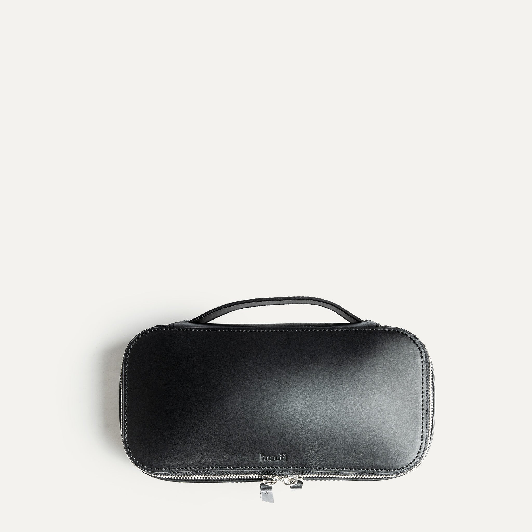 Vu de dessus de la trousse de toilette homme luxe pensé par lundi en cuir noir.