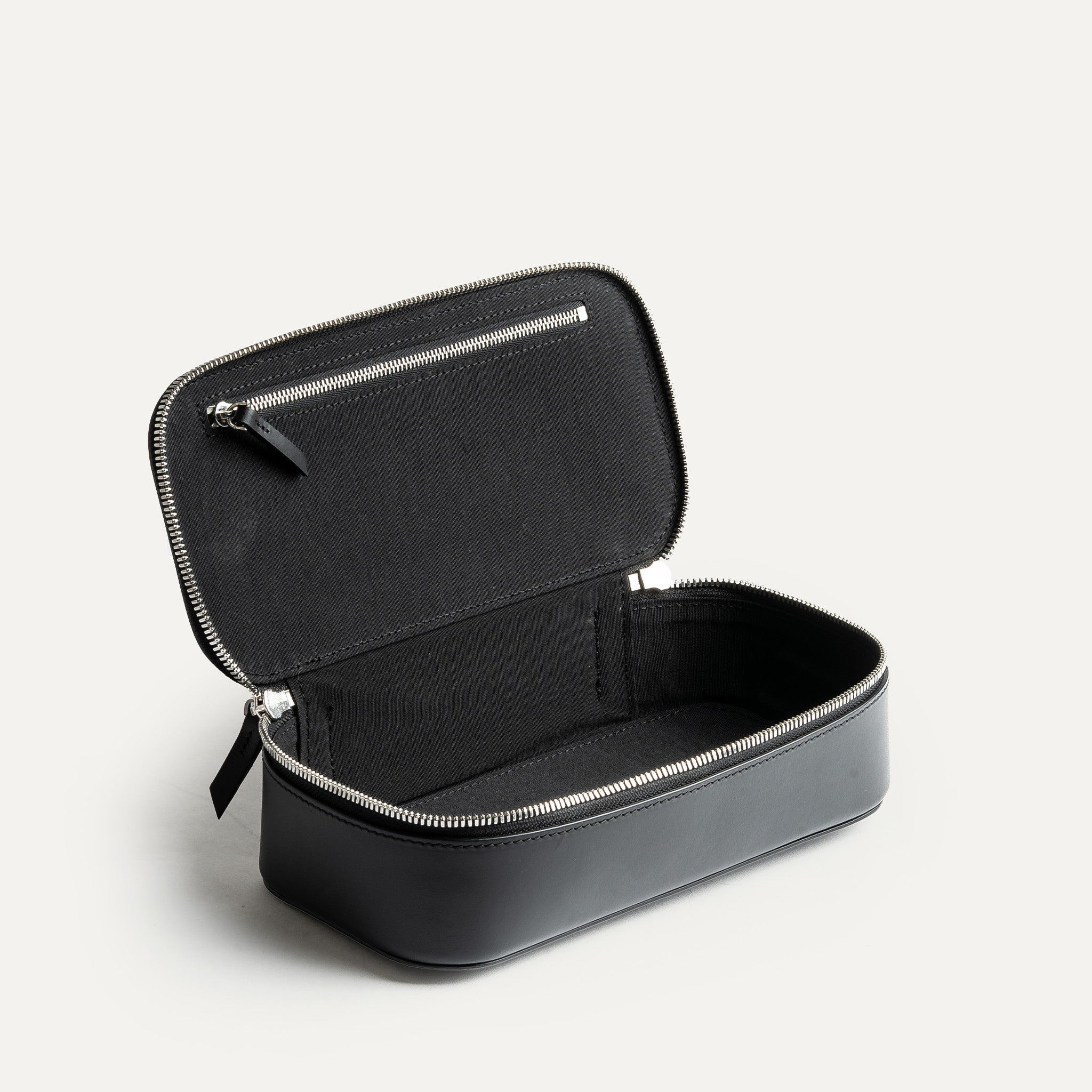 Vu intérieur de la trousse de toilette homme en cuir noir pensé par lundi pour être pratique et élégante.