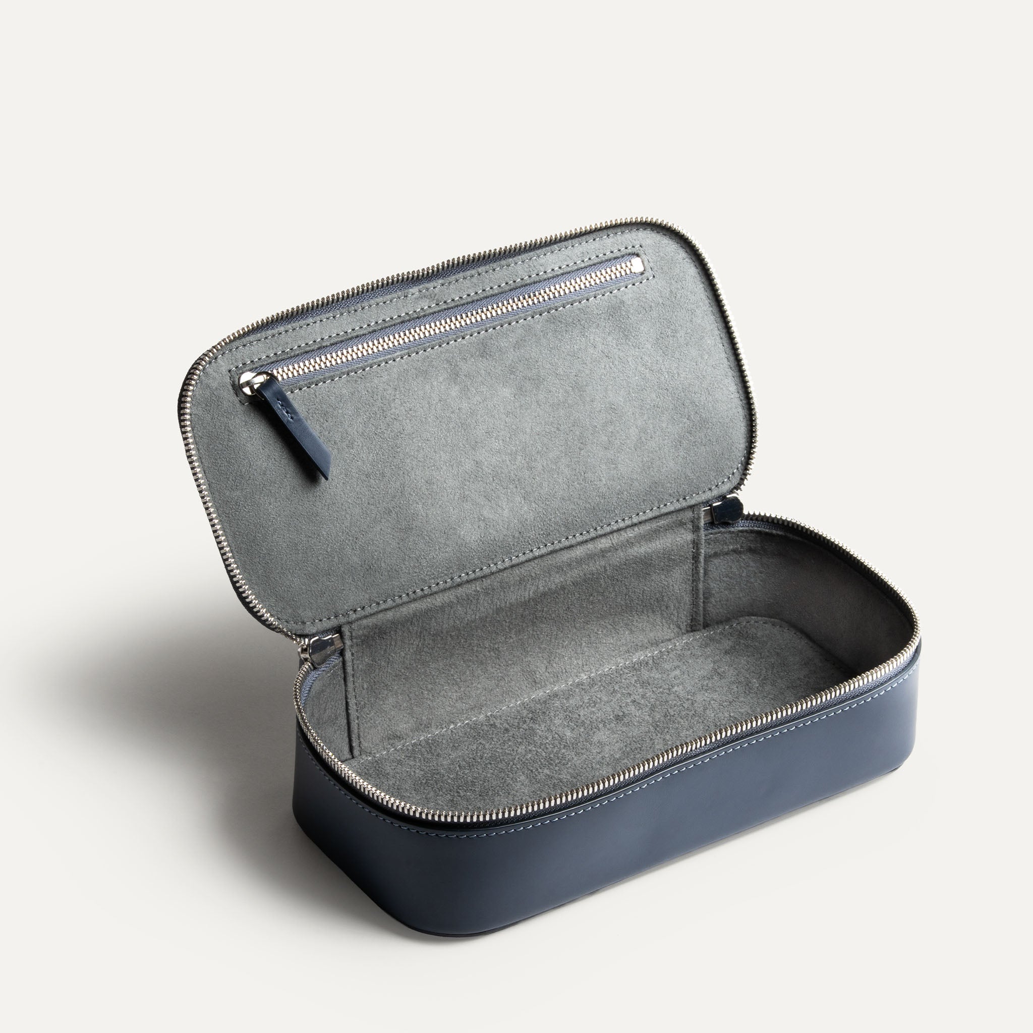 Grande trousse de toilette avec compartiment intérieur vide et poche zippée pour accessoires.