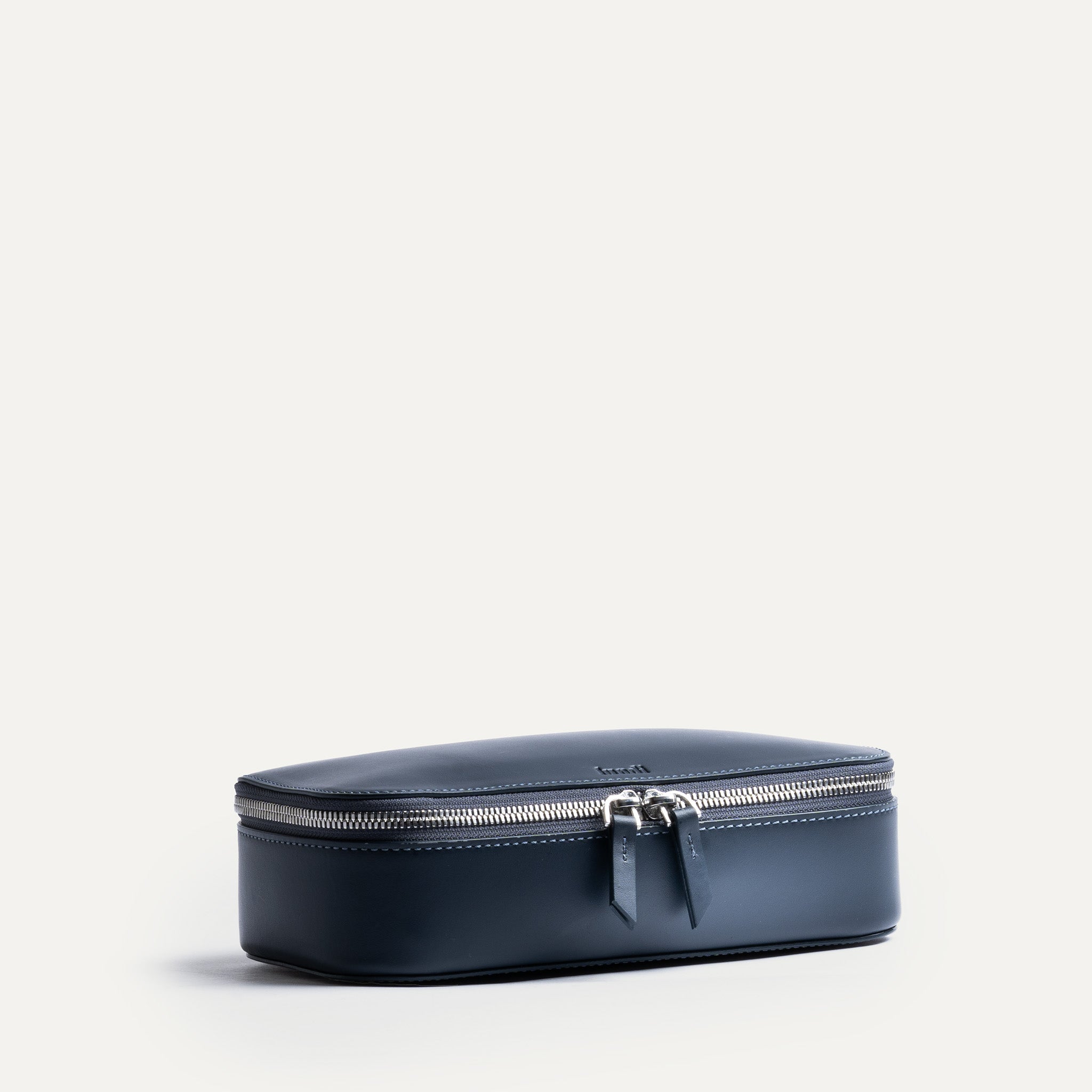 Trousse de toilette homme cuir bleu marine élégante et compacte avec fermeture éclair métallique double.