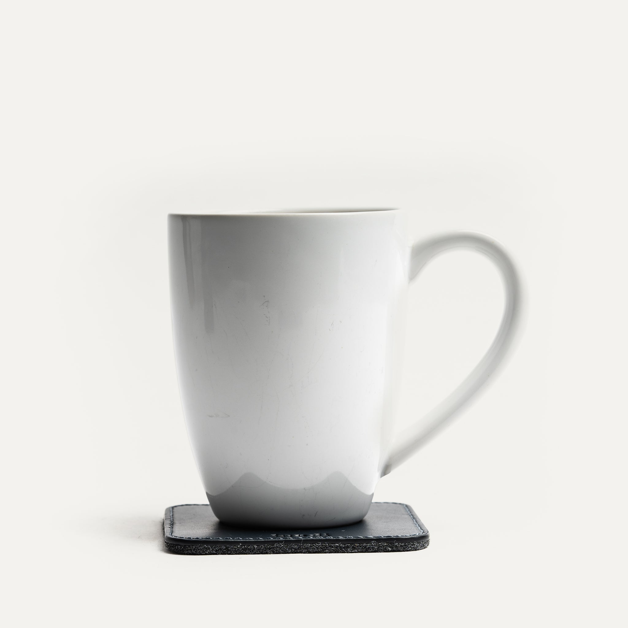 Sous tasse lundi réversible de couleur bleu marine, robuste en cuir.