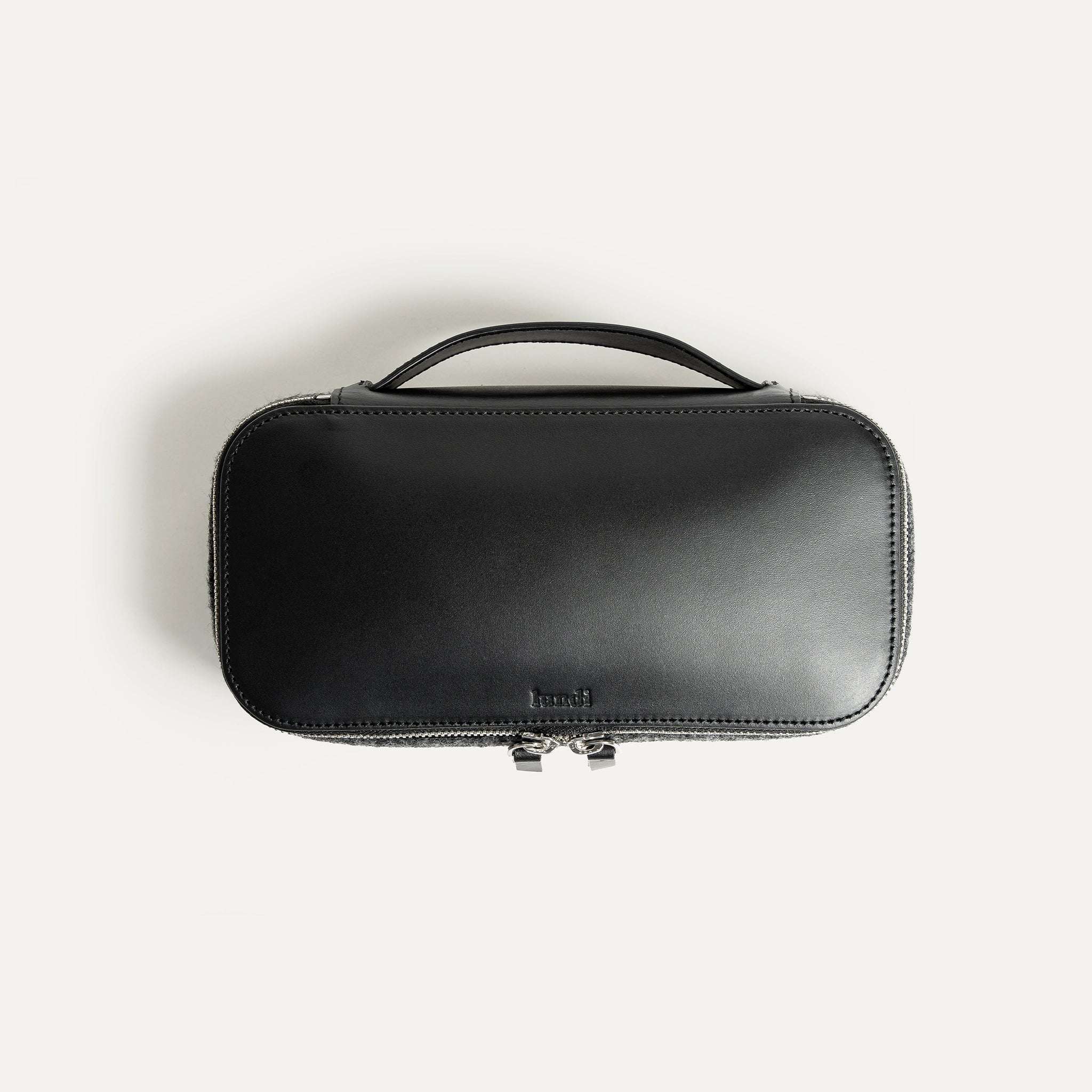 Un cuir au tannage végétal est utilisé pour la construction de cette trousse de toilette. logo lundi embossé
