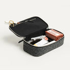 Intérieur d'une trousse de toilette en cuir et feutrine, avec tous les accessoires indispensables pour voyager