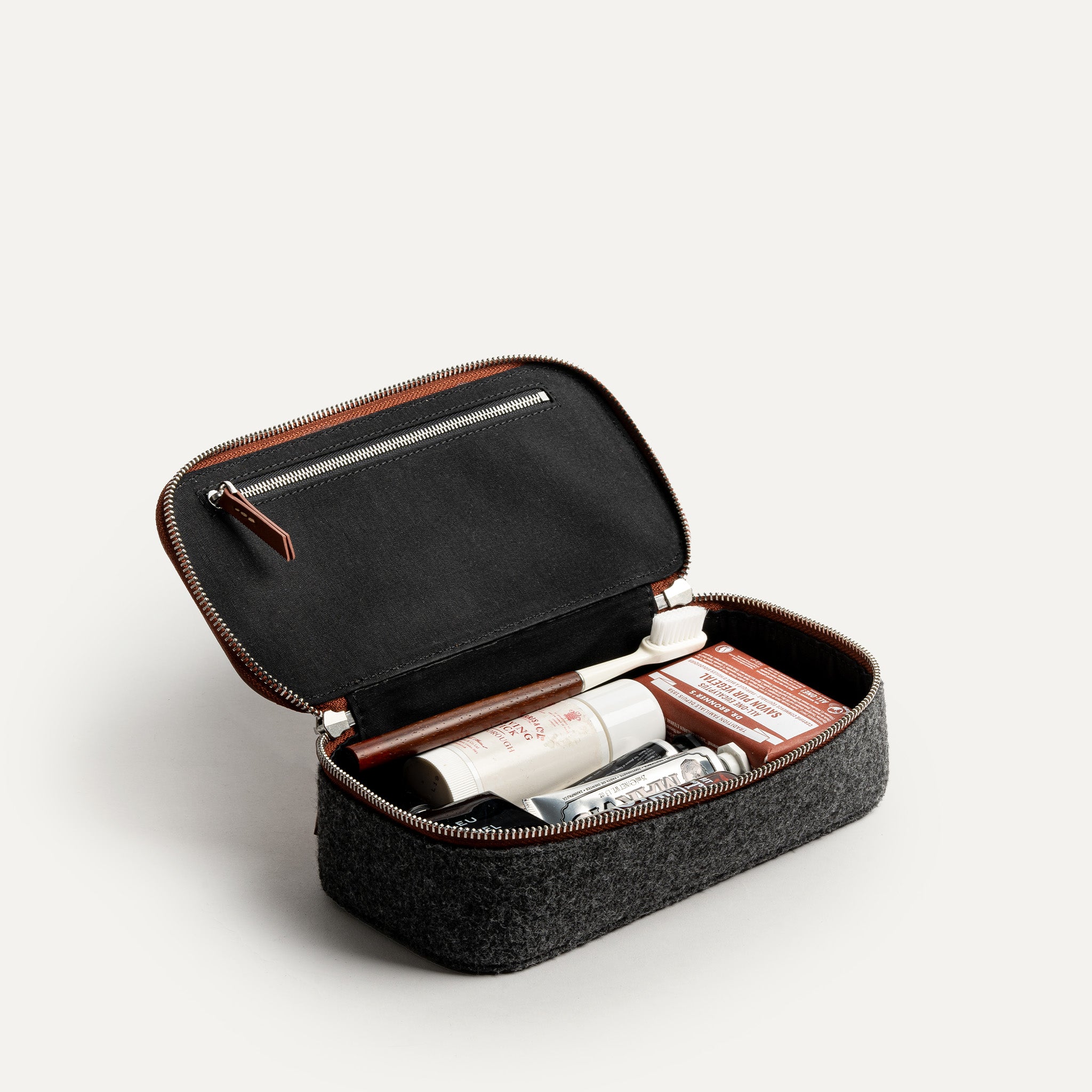Trousse de toilette femme grand format ouverte, montrant les compartiments intérieurs et les produits de soin organisés.