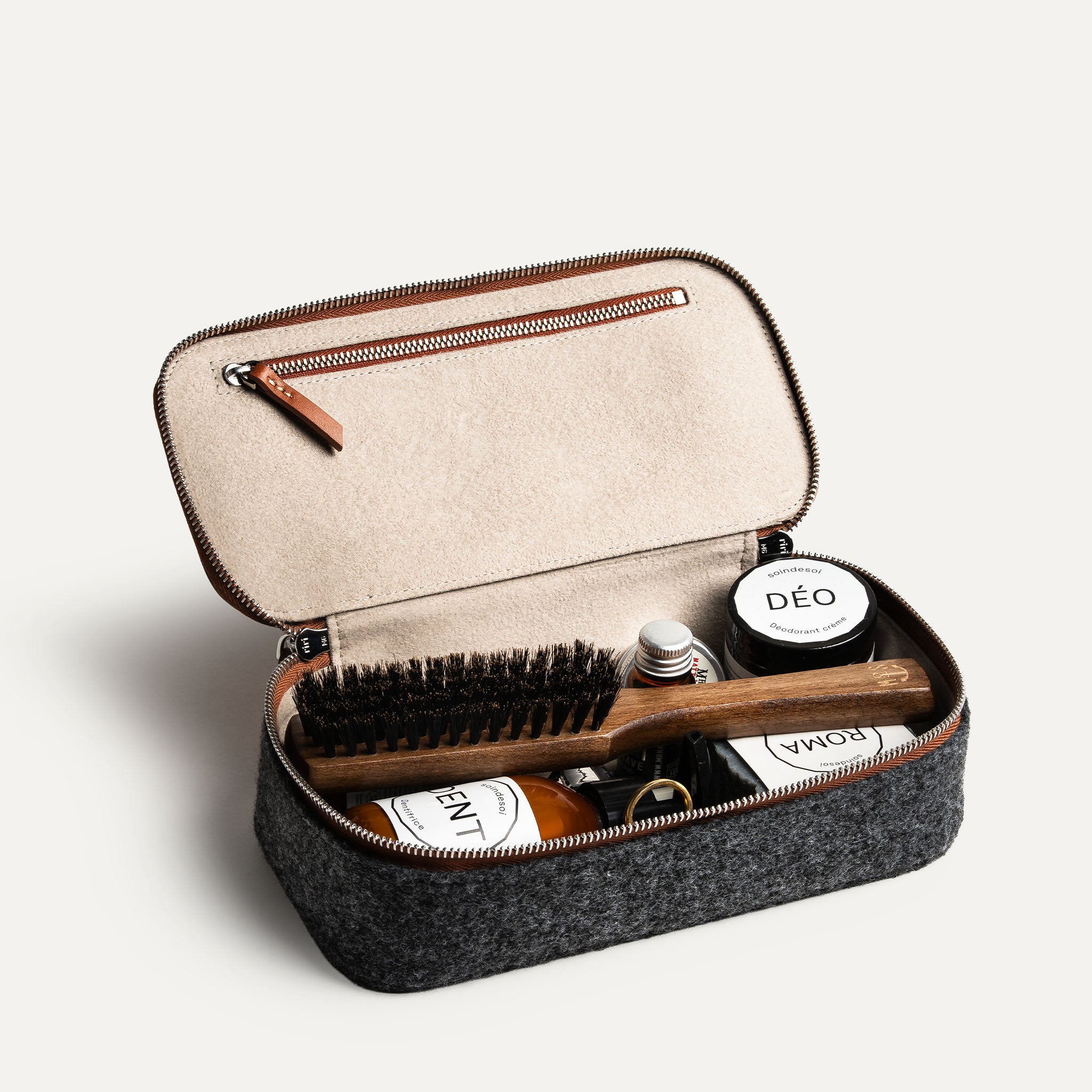 Trousse de toilette femme grand format ouverte, montrant les compartiments intérieurs et les produits de soin organisés.