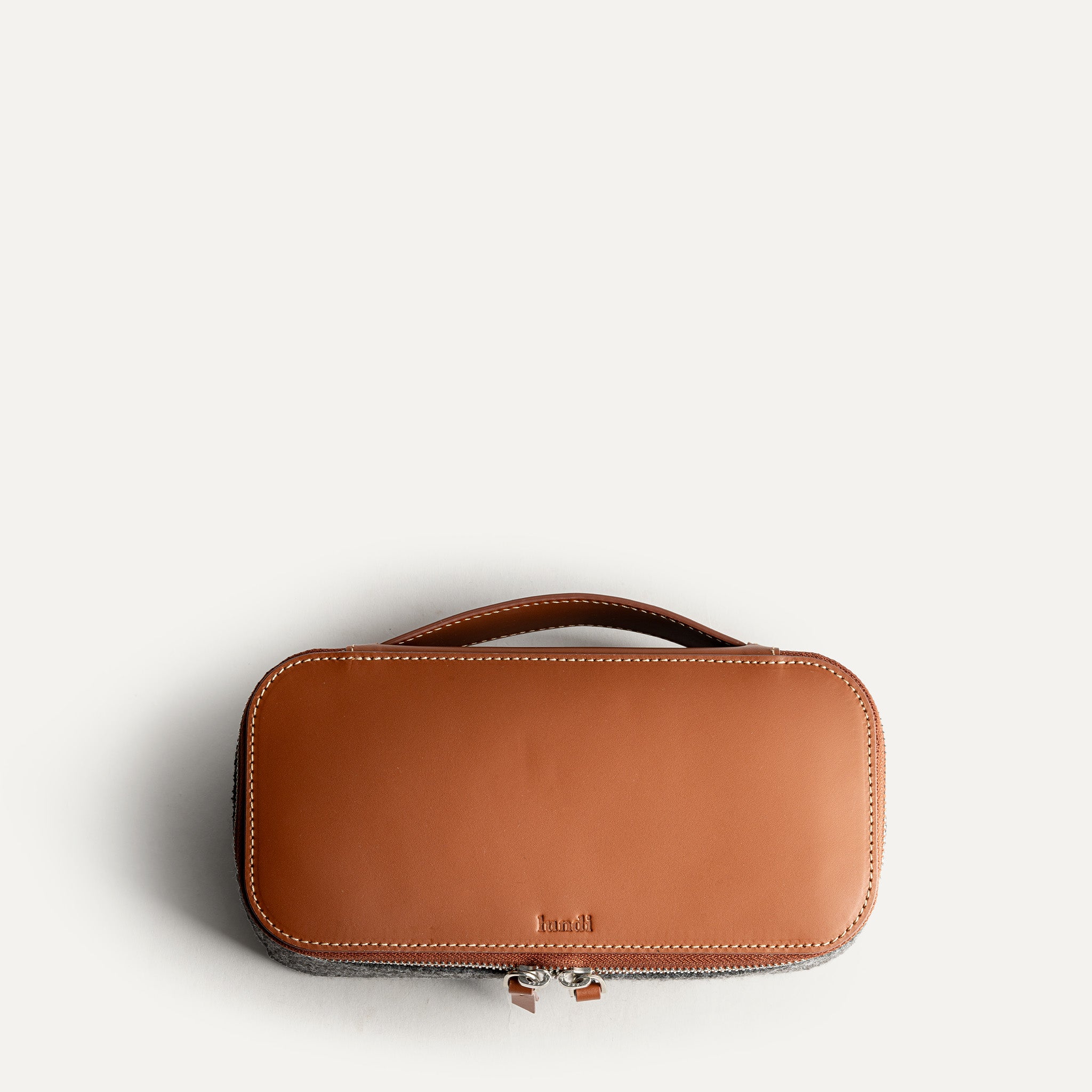 Grande trousse de toilette pour homme vue de dessus, en cuir camel et feutre gris, élégante et pratique.