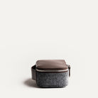 Trousse de toilette avion compacte et élégante, en cuir marron et feutre gris, vue de côté.