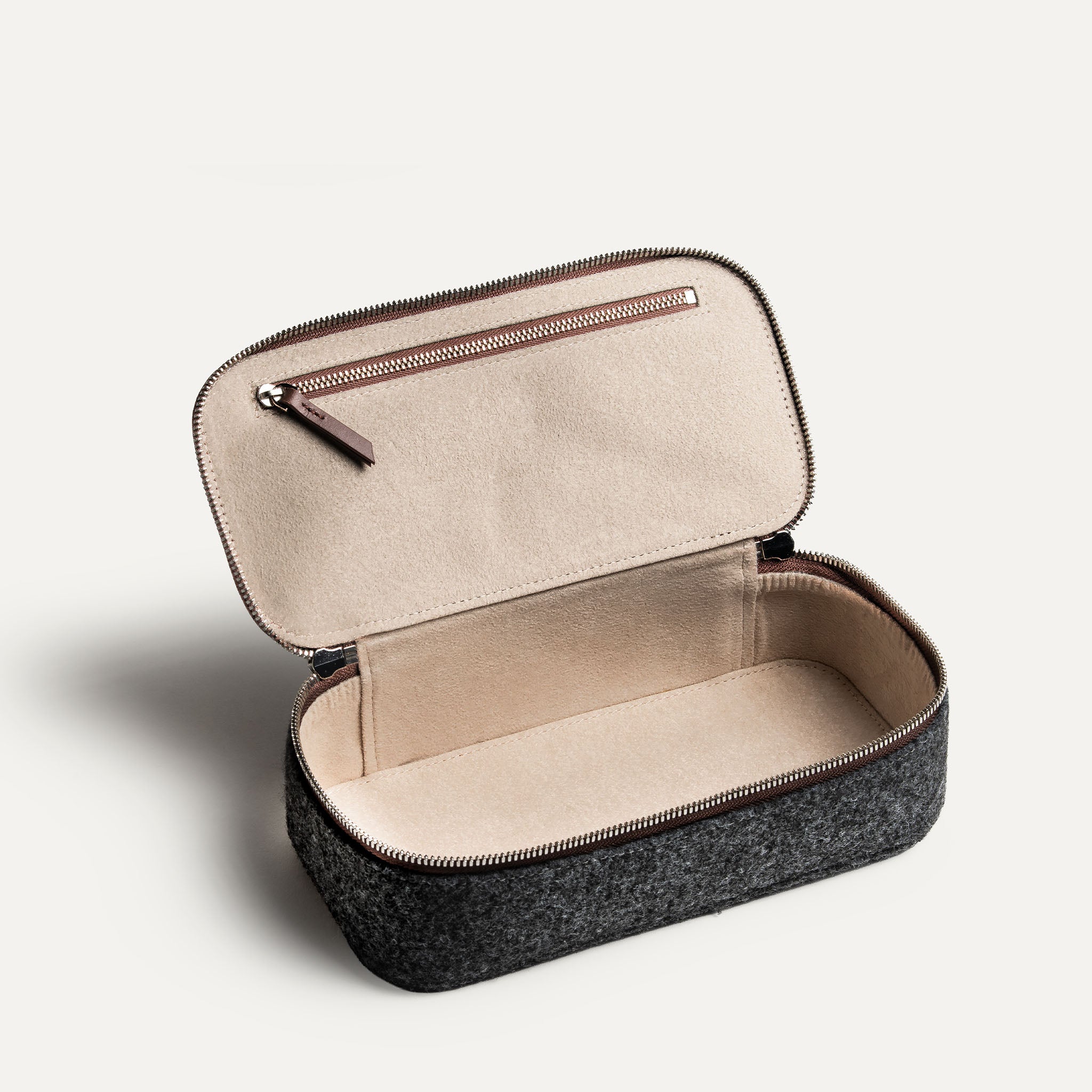 Grande trousse de toilette avec compartiment intérieur pratique, en cuir marron et feutre gris.