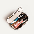 Trousse de toilette cuir pour homme vue ouverte, contenant des produits de soin et accessoires.