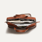 Compartiment principal ouvert du sac ordinateur, révélant de nombreux rangements pour documents, stylos, tablette et ordinateur portable.