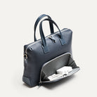 Compartiment avant d’un porte document homme en cuir grainé bleu, ouvert avec un chargeur.