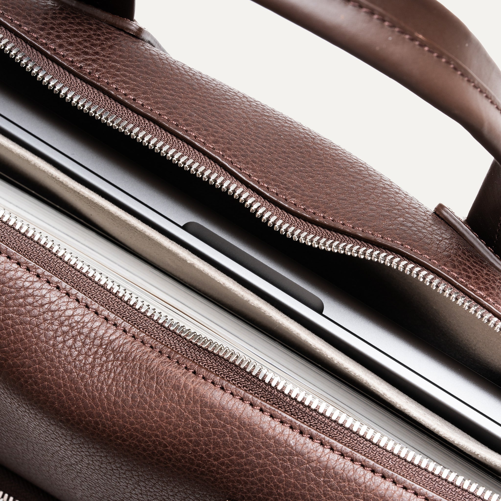 Compartiment intérieur rembourré avec un ordinateur portable glissé à l’intérieur d’un sac ordinateur en cuir.