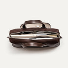 Cartable cuir homme bien rempli avec un compartiment ordinateur portable, livres et accessoires.