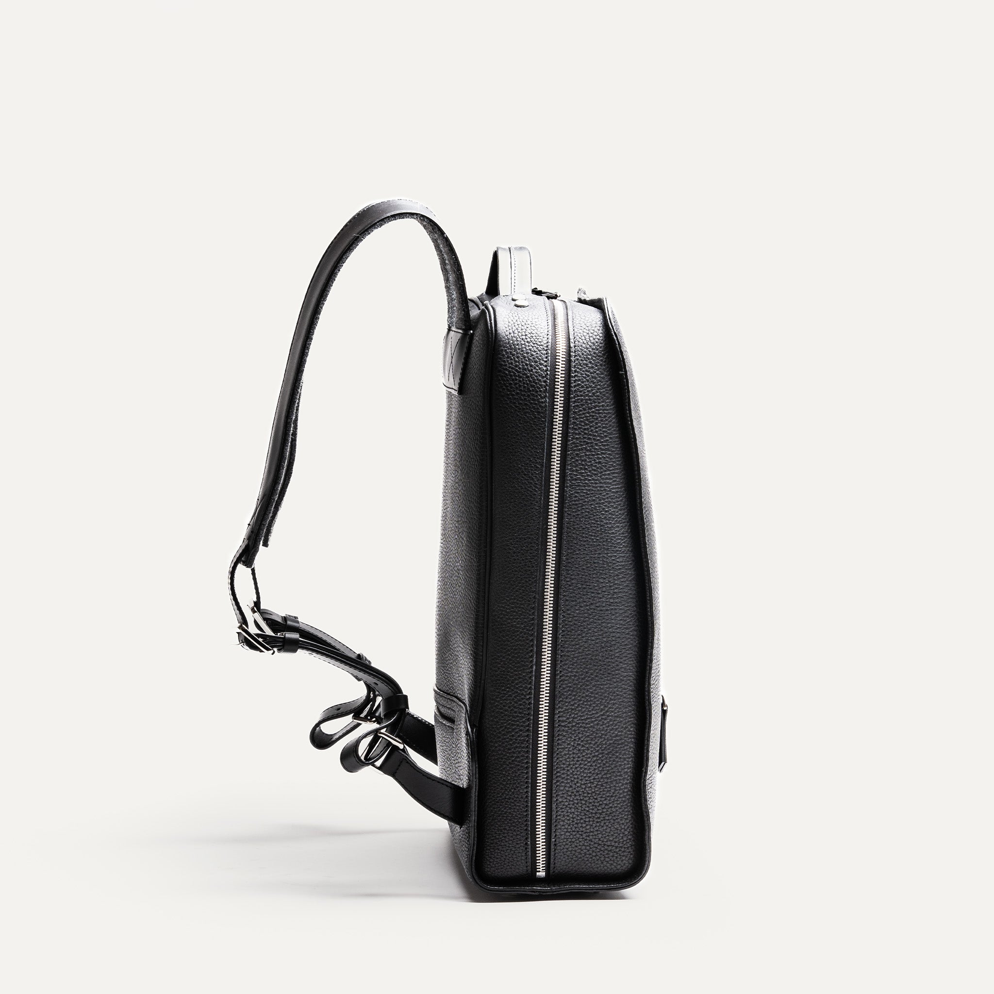Côté du sac à dos ordinateur homme en cuir noir, silhouette fine.