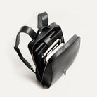 sac à dos urbain homme en cuir noir, silhouette structurée et élégante.
