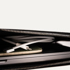 Intérieur d'une pochette ordinateur cuir avec poches plates pour chargeur et carnet.