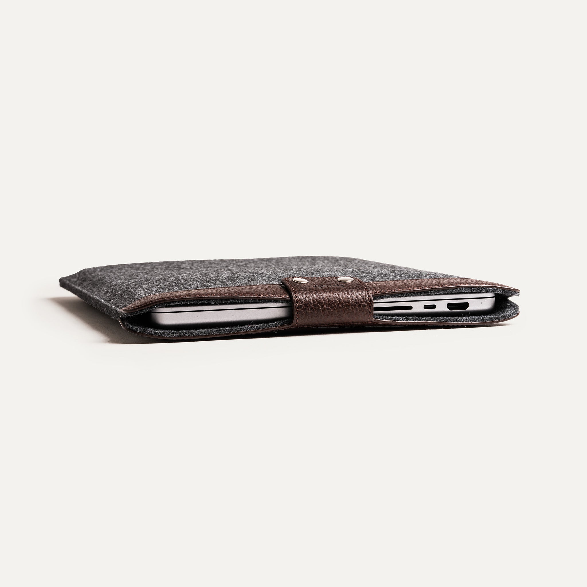 Pochette Mac en cuir marron, profil fin et protection ajustée.