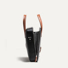 Sac à main homme ouvert révélant un intérieur spacieux avec poches plates, porte-stylo et maintien sécurisé pour câbles et chargeur.