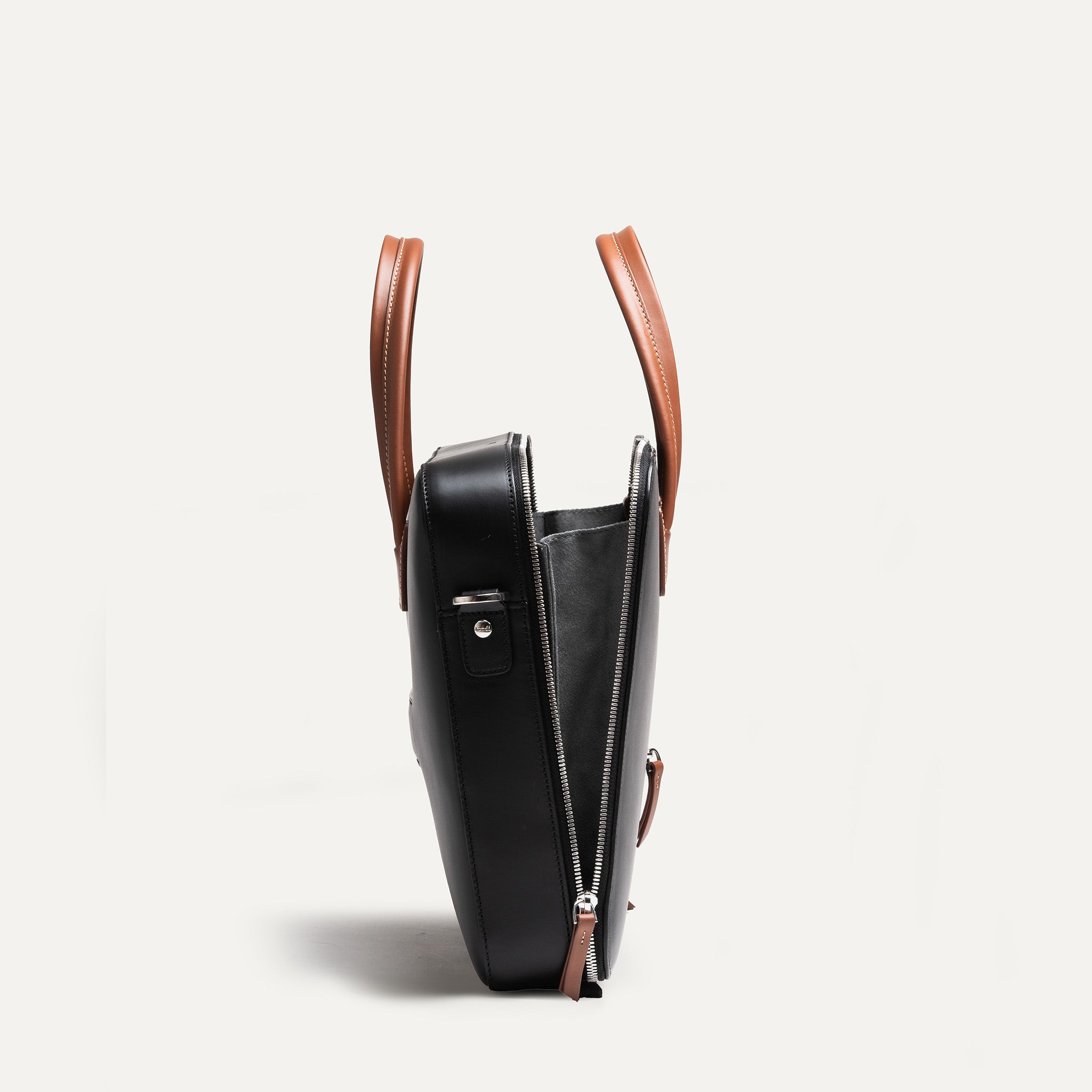 Sac à main homme ouvert révélant un intérieur spacieux avec poches plates, porte-stylo et maintien sécurisé pour câbles et chargeur.