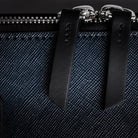 Porte document avec des finitions en laiton et fermeture éclair robuste.