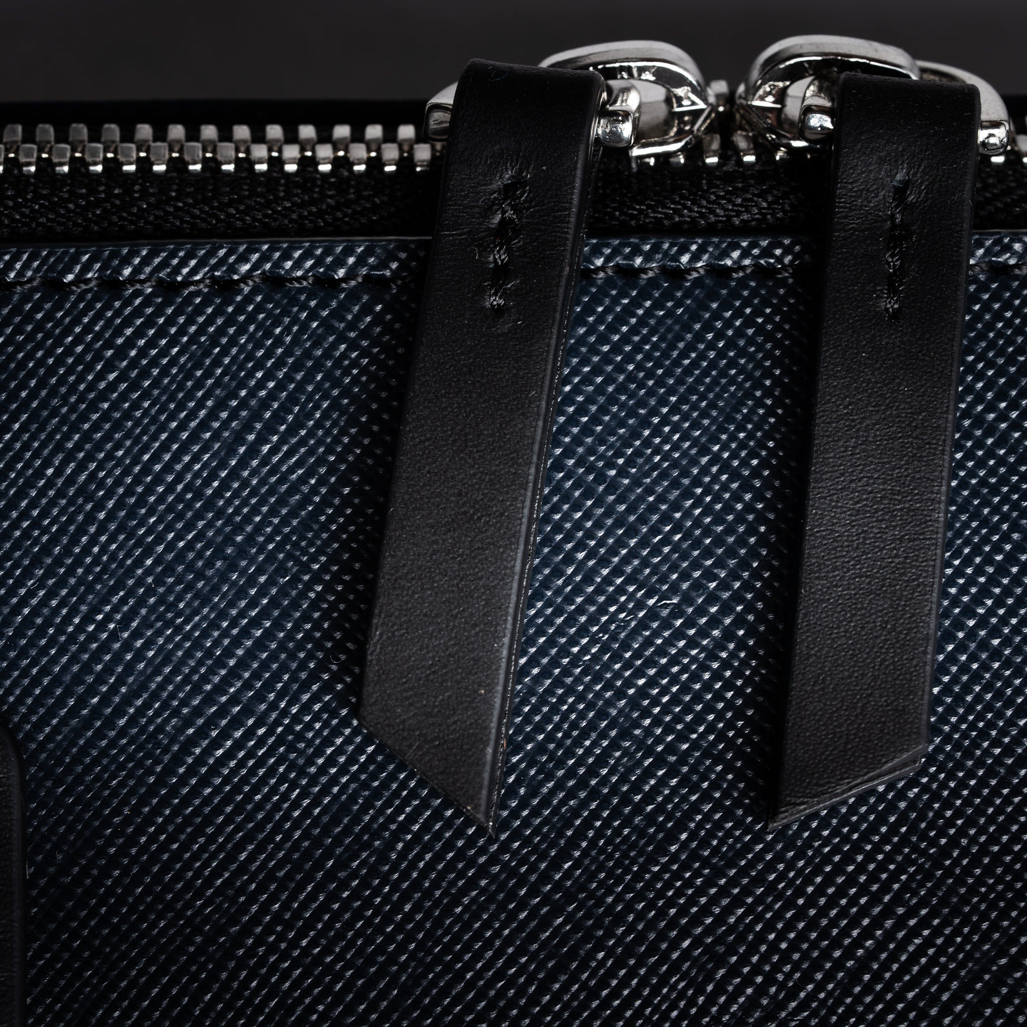 Porte document avec des finitions en laiton et fermeture éclair robuste.